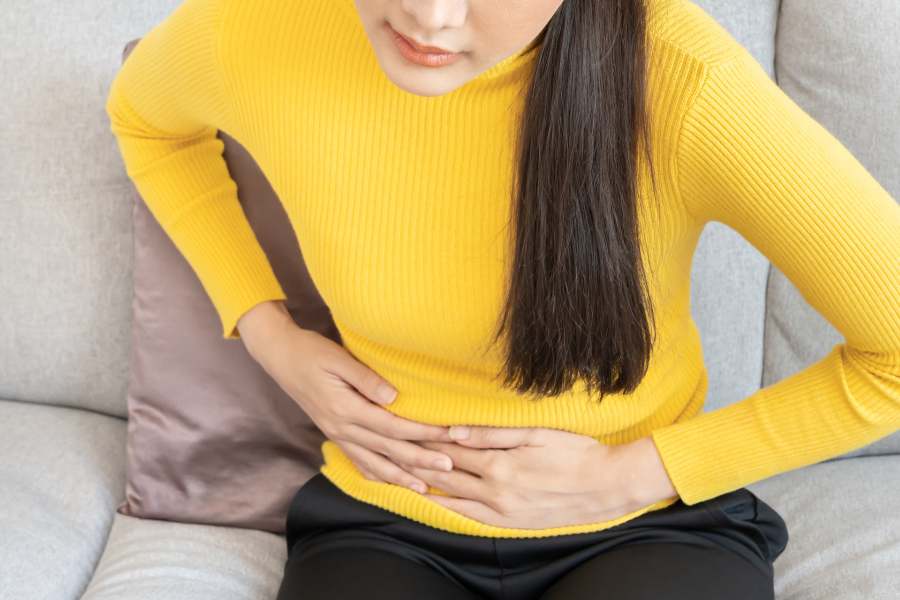 Kobieta trzymająca się z bólu za brzuch